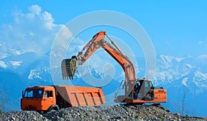 Excavator loads rubble into a truck