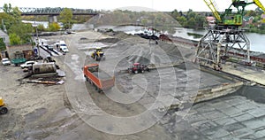 An excavator loads rubble in a truck body, loading a truck aerial view