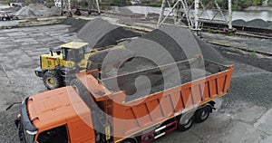 An excavator loads rubble in a truck body, loading a truck aerial view