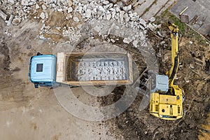 Excavator loads sand in a truck top view