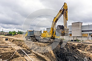 Excavator loads soil into the truck