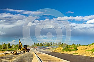 Excavator loads truck, construction bypass road