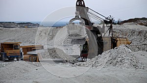 Excavator loads a truck rock in the quarry