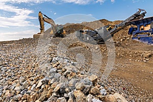 Excavator and machine to pulverize stone in a quarry photo