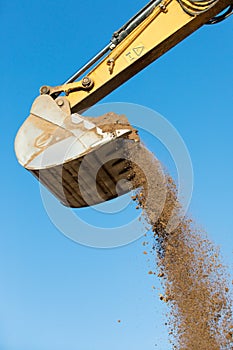 Excavator machine unloading sand at construction site