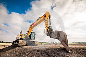 Excavator on mound at construction site