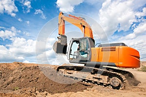 Excavator moves with raised bucket during earth moving works