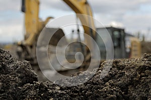 an excavator moving dirt in a construction yard