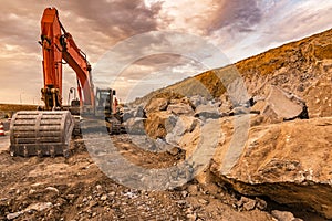 Excavator moving earth and stone in the construction works of a road