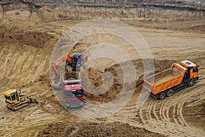 Excavator moving earth and unloading into a dumper truck