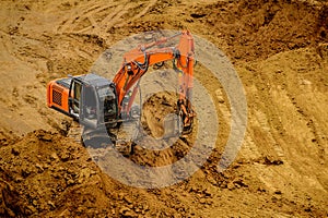 Excavator moving earth and unloading into a dumper truck