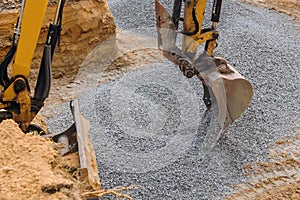 Excavator moving gravel in house under construction