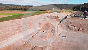 Excavator moving loaded sand at open mining. Bulldozer at quarry loading sand