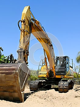 Excavator parked in the sand ready for maintenance work on the beach