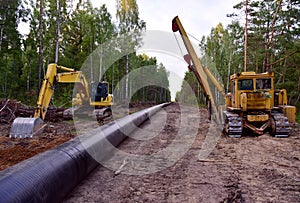 Excavator and Pipelayer with side boom o  Installation of  gas and crude oil pipes in ground. Construct of the gas pipes to new