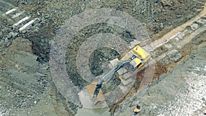 Excavator is pouring sand into the quarry with water