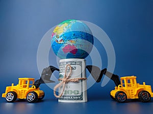 Excavator pushing earth globe and banknotes on blue background