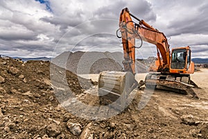 Excavator in a quarry extracting stone