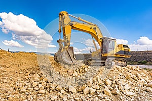 Excavator in a quarry extracting stone