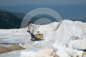 The excavator in quarry for the extraction of marble