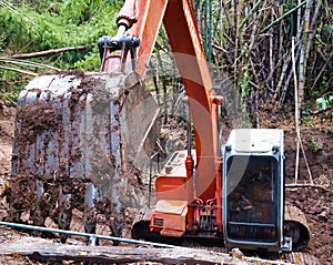 Excavator ripper bucket with earth attached to it.