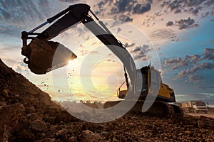 Excavator at sandpit during earthmoving works in the construction site photo