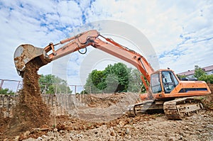 Excavator at sandpit during earthmoving works photo