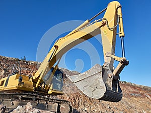 Excavator scoop during road construction on the rocky soils