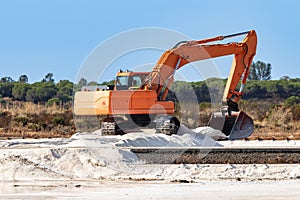 Excavator stacking sea salt. The traditional production of sea salt is the salt that is produced by the evaporation of sea water