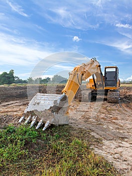 Excavator standing with cloudscape sky