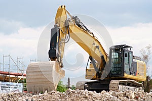 Excavator stands on rubble heap