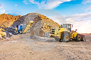 Excavator and stone crusher in a quarry