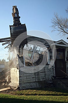 Excavator tearing apart a house