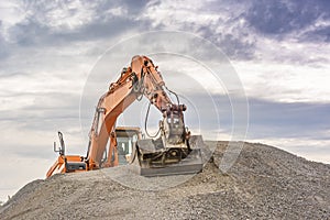 Excavator on top of a ballast pile