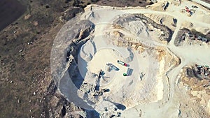 Excavator and truck are working in the sand quarry. Aerial view of loading sand into a truck