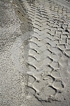 Excavator tyres footprint on quarry white sand