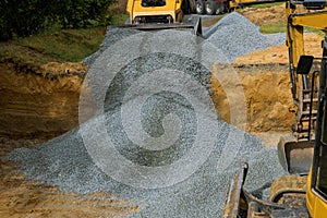 Excavator unloading gravel in the construction works of foundation