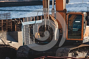 Excavator unloading sand into the dump truck on the construction site, excavating and working during road works, backhoe and