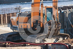 Excavator unloading sand into the dump truck on the construction site, excavating and working during road works, backhoe and