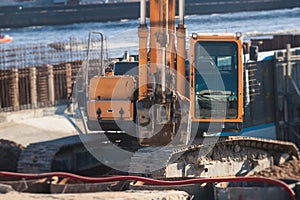 Excavator unloading sand into the dump truck on the construction site, excavating and working during road works, backhoe and