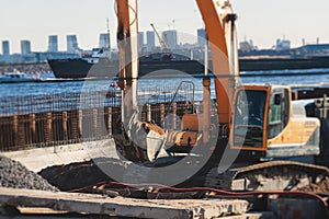 Excavator unloading sand into the dump truck on the construction site, excavating and working during road works, backhoe and