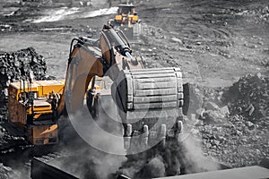 Excavator work loading of coal into Yellow mining truck. Open pit mine industry