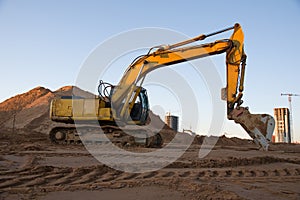 Excavator working at construction site. Backhoe digs ground for the foundation and for paving out sewer line.