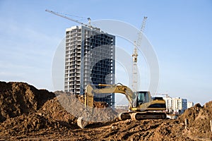 Excavator working at construction site. Backhoe digs ground for the foundation and for paving out sewer line