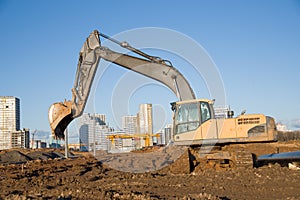 Excavator working at construction site. Backhoe digs ground for the foundation and for paving out sewer line