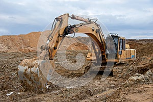 Excavator working at construction site. Backhoe digs ground for the foundation and for paving out sewer line. Construction