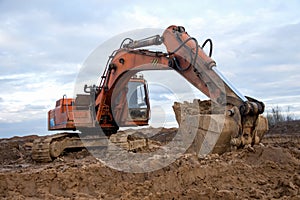 Excavator working at construction site. Backhoe digs ground for the foundation and for paving out sewer line. Construction