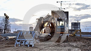 Excavator working at construction site. Backhoe digs ground for the foundation and for paving out sewer line. Construction