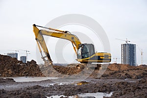 Excavator working at construction site. Backhoe digs ground for the foundation and for paving out sewer line. Construction