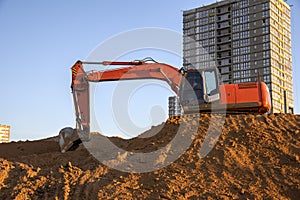 Excavator working at construction site. Backhoe during earthworks. Digging ground for the foundation and for laying sewer pipes